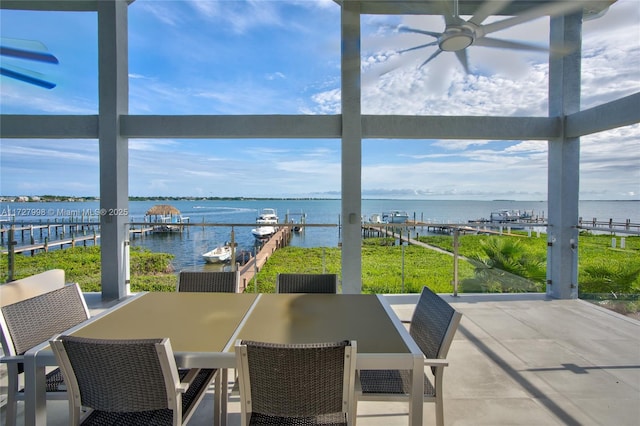 sunroom featuring a water view and ceiling fan