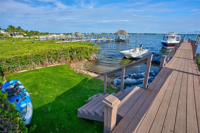 dock area featuring a water view and a lawn