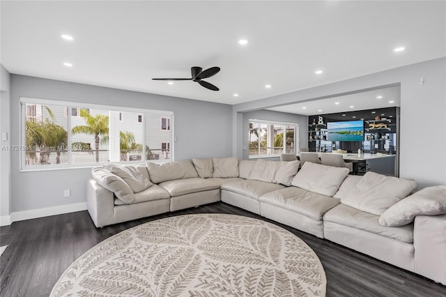 living room featuring ceiling fan and dark hardwood / wood-style flooring