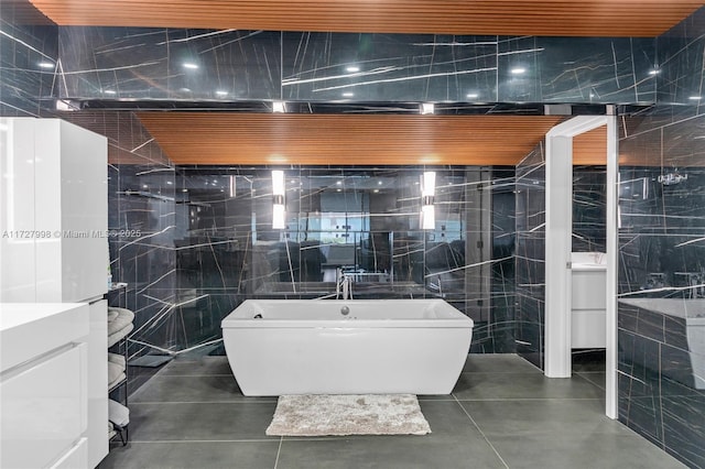 bathroom with wood ceiling, tile walls, and a bathtub