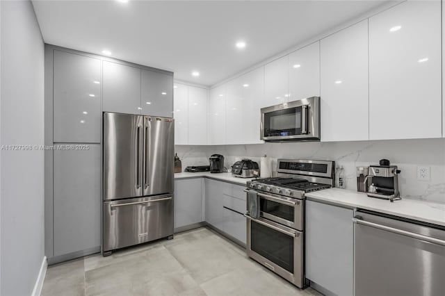 kitchen featuring appliances with stainless steel finishes, white cabinetry, and tasteful backsplash