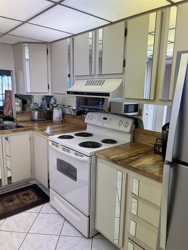 kitchen with custom exhaust hood, appliances with stainless steel finishes, wood counters, and white cabinetry