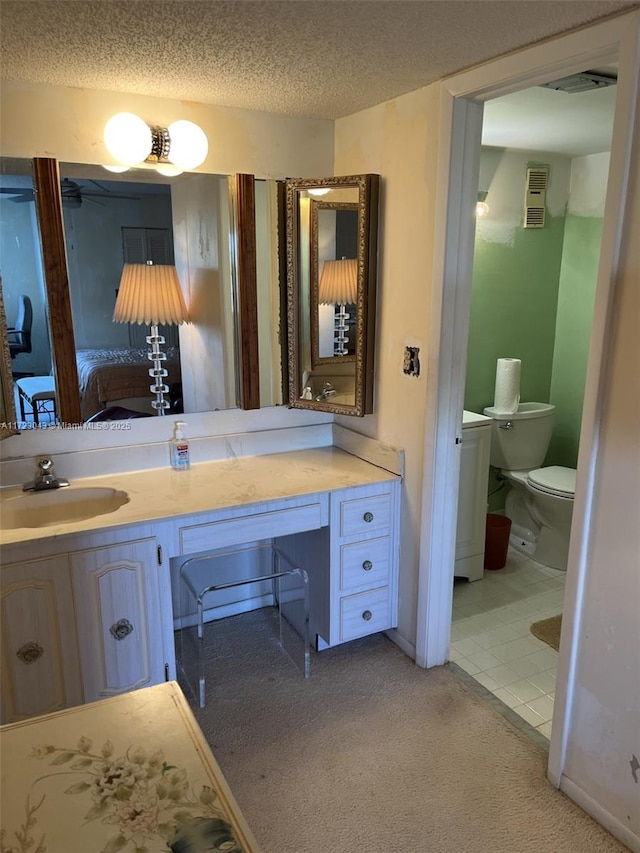 bathroom featuring a textured ceiling, toilet, and vanity