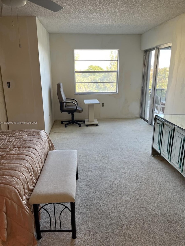 bedroom featuring a textured ceiling, ceiling fan, light colored carpet, and access to outside