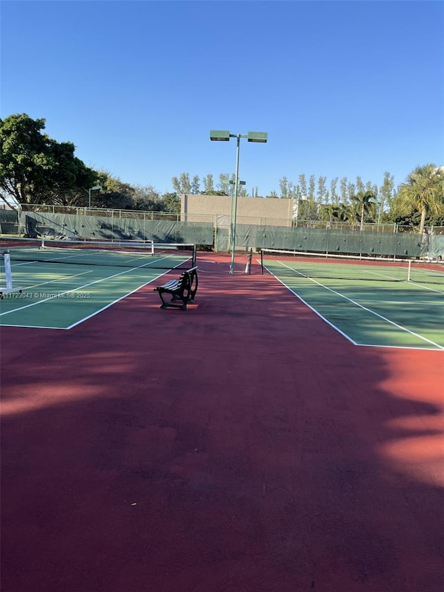 view of tennis court with basketball hoop