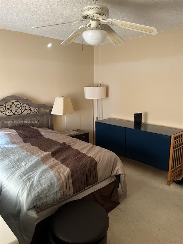 carpeted bedroom featuring ceiling fan and a textured ceiling