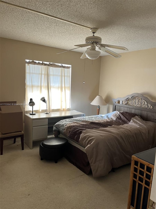 bedroom featuring ceiling fan, a textured ceiling, and light carpet