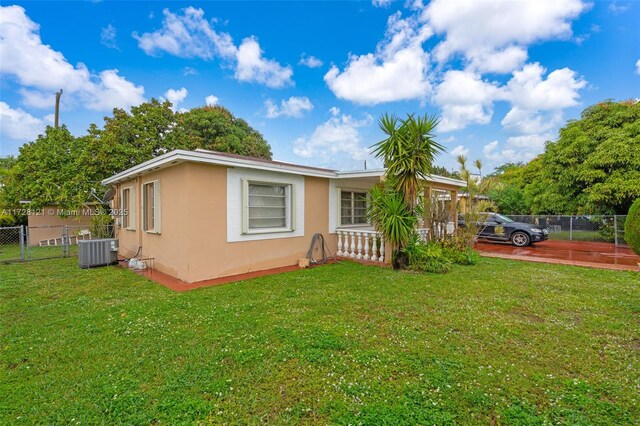 view of front of property featuring a front yard and cooling unit