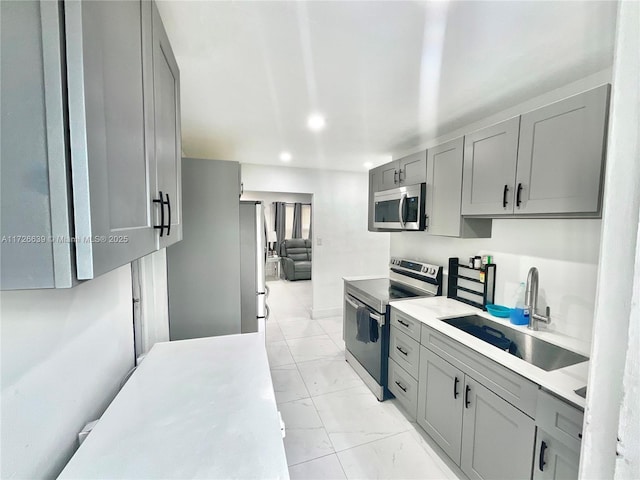 kitchen featuring sink, gray cabinetry, and stainless steel appliances