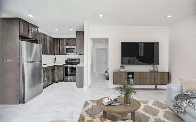 kitchen with appliances with stainless steel finishes, sink, and dark brown cabinets