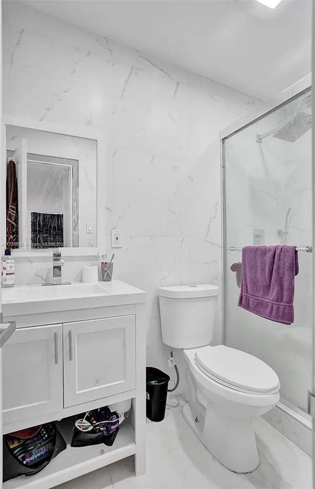 bathroom featuring a shower with shower door, vanity, and toilet