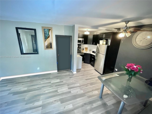 kitchen featuring light wood-type flooring, ceiling fan, and appliances with stainless steel finishes