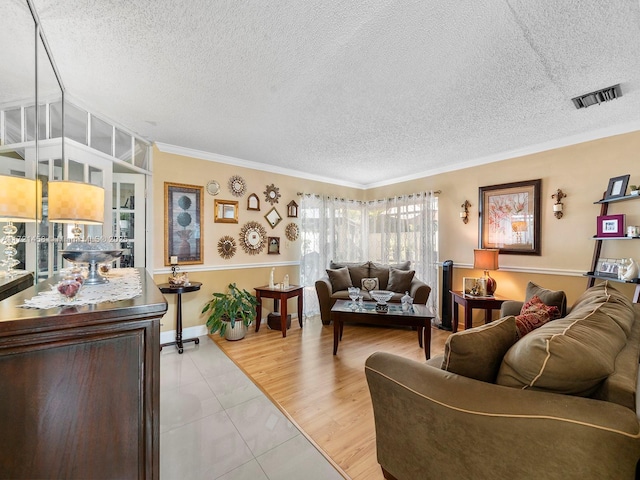 living room with light tile patterned floors, crown molding, and a textured ceiling