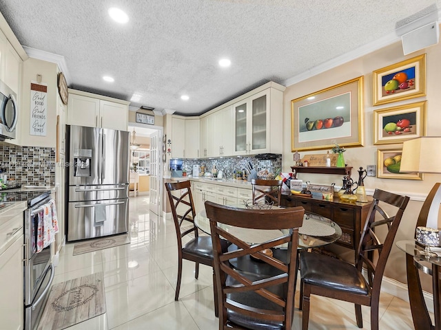 kitchen featuring light tile patterned floors, backsplash, appliances with stainless steel finishes, and a textured ceiling