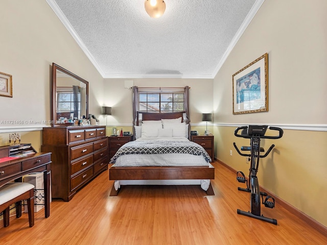 bedroom featuring ornamental molding, multiple windows, light hardwood / wood-style flooring, and a textured ceiling