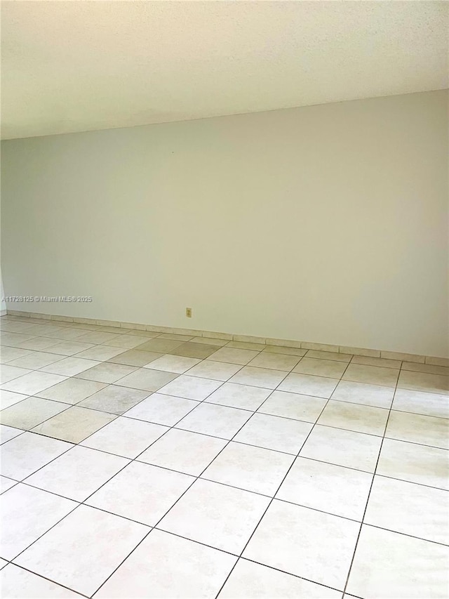 unfurnished room with light tile patterned flooring