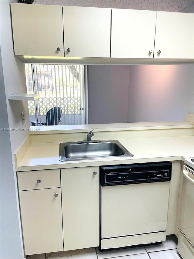 kitchen featuring light tile patterned flooring, white cabinetry, dishwasher, and sink