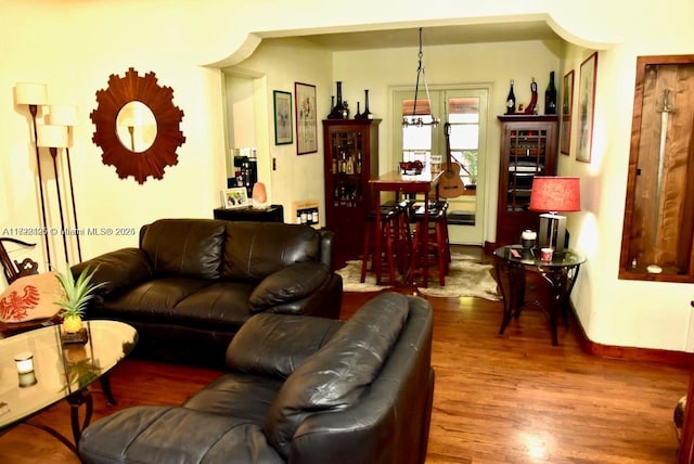 living room featuring wood-type flooring and a chandelier