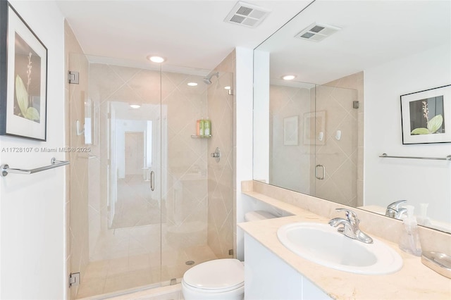 bathroom with toilet, an enclosed shower, and vanity