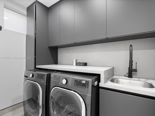 clothes washing area featuring cabinets, independent washer and dryer, and sink