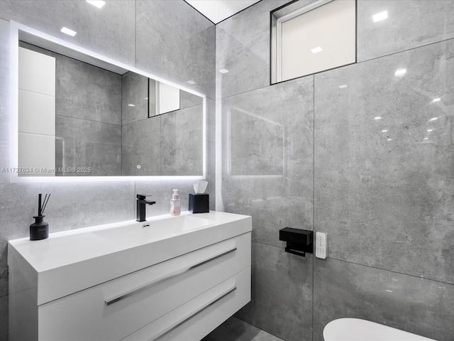 bathroom featuring toilet, vanity, and tasteful backsplash