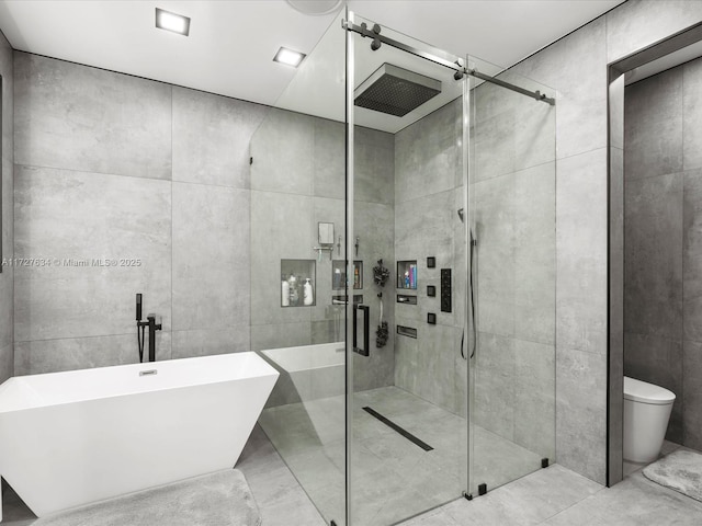 bathroom featuring toilet, shower with separate bathtub, and tile walls