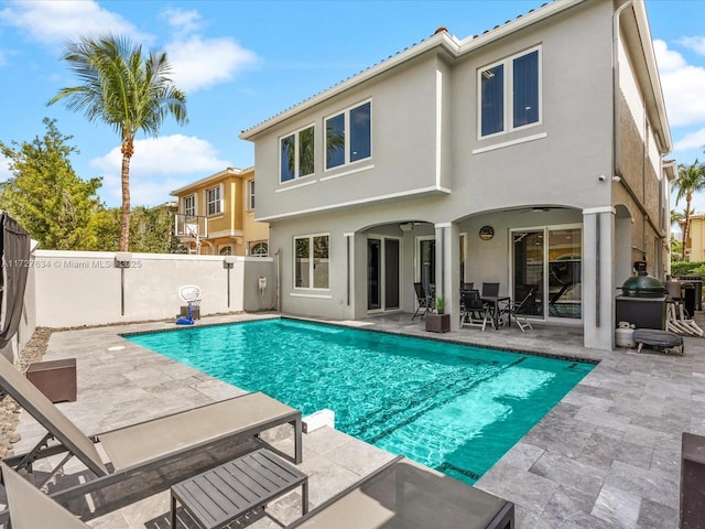 back of house with a patio area, a fenced in pool, and ceiling fan