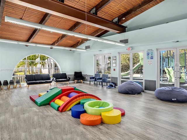 rec room featuring hardwood / wood-style floors, beamed ceiling, high vaulted ceiling, french doors, and wooden ceiling