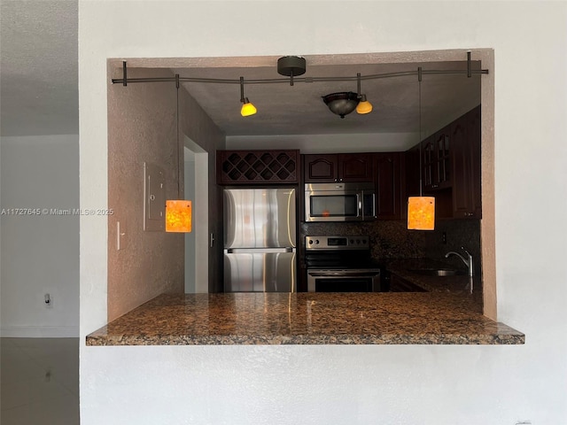 kitchen featuring dark stone countertops, decorative backsplash, sink, dark brown cabinetry, and stainless steel appliances