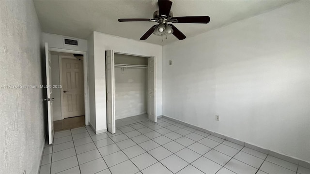 unfurnished bedroom featuring ceiling fan and a closet