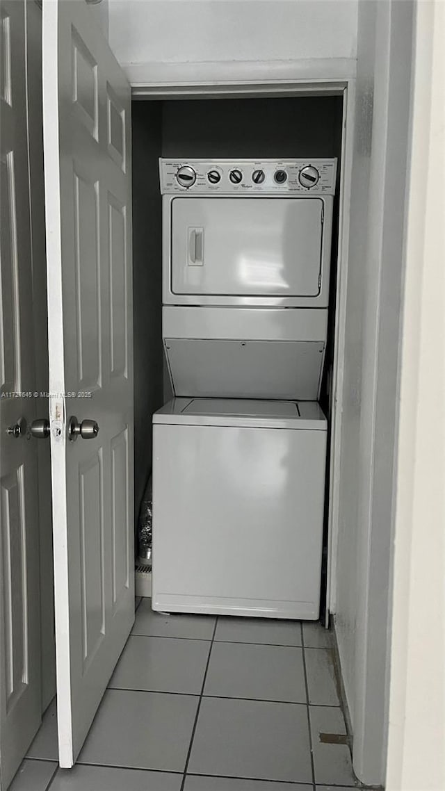 washroom featuring light tile patterned floors and stacked washer / drying machine