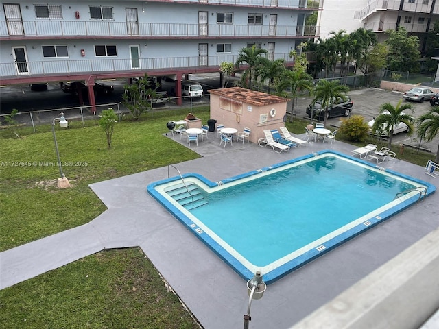 view of pool featuring a yard, a storage unit, and a patio