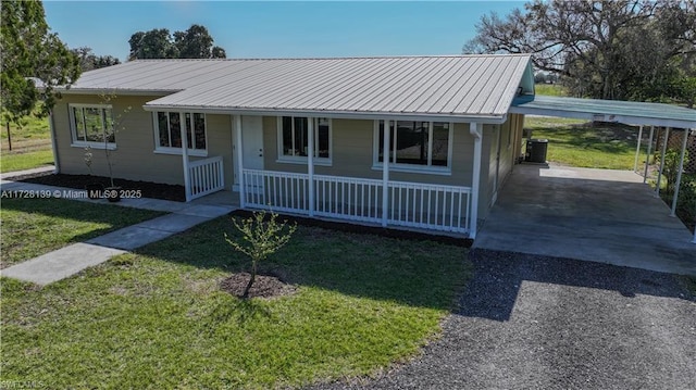 view of front facade with cooling unit, a carport, a porch, and a front yard