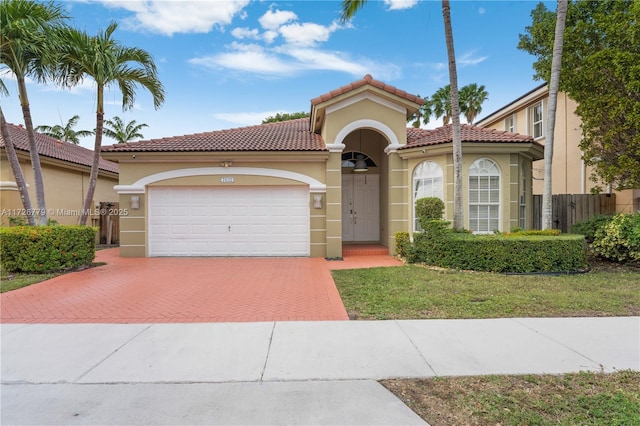 mediterranean / spanish house with a front yard and a garage