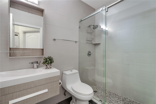 bathroom featuring an enclosed shower, vanity, tasteful backsplash, tile walls, and toilet