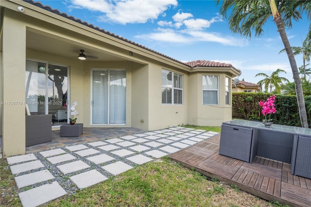 rear view of house with ceiling fan, an outdoor living space, and a patio