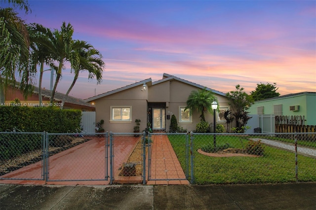 mid-century modern home featuring a fenced front yard, a gate, and stucco siding