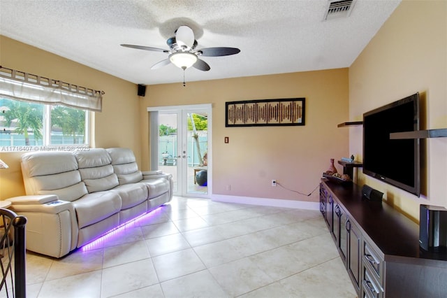 living room featuring baseboards, visible vents, a textured ceiling, and french doors