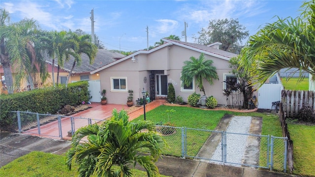 view of front of house featuring a fenced front yard, a gate, and stucco siding