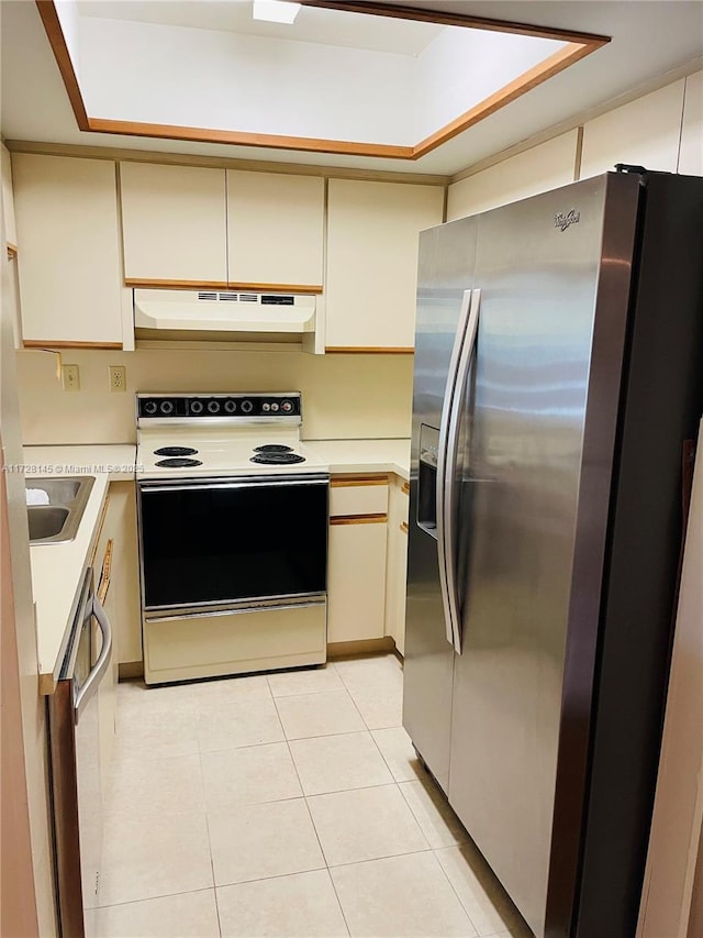 kitchen featuring sink, light tile patterned floors, stainless steel appliances, and cream cabinetry