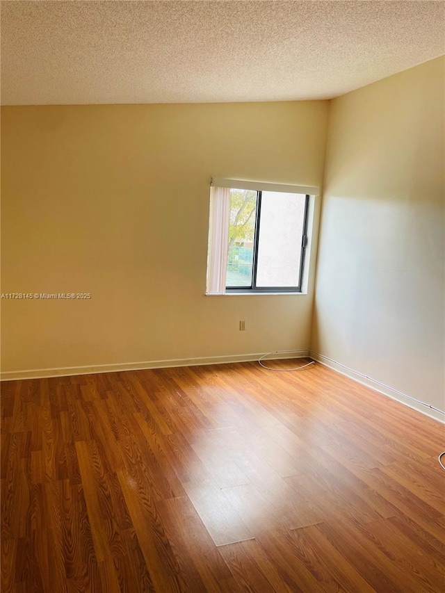 unfurnished room featuring a textured ceiling and hardwood / wood-style flooring