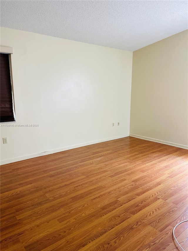 empty room with a textured ceiling and hardwood / wood-style floors