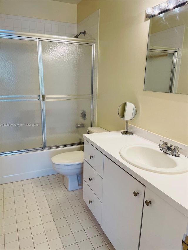 full bathroom with toilet, combined bath / shower with glass door, tile patterned floors, and vanity