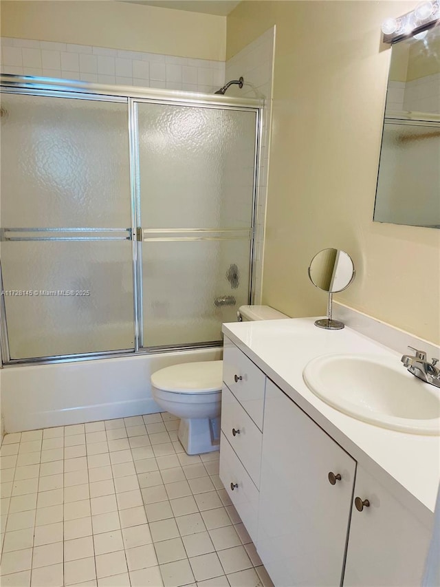 full bathroom with toilet, tile patterned floors, enclosed tub / shower combo, and vanity