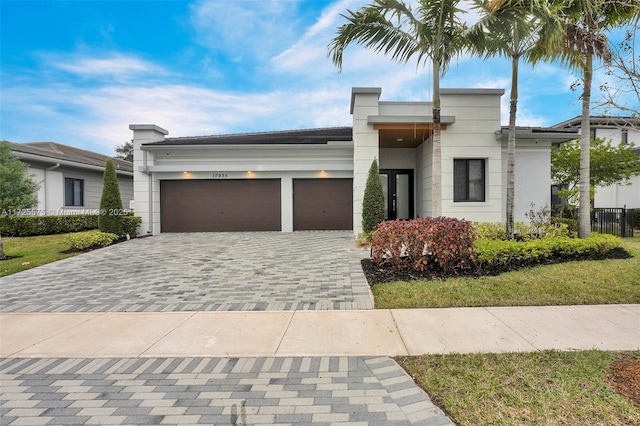 view of front of house featuring a garage, decorative driveway, and stucco siding