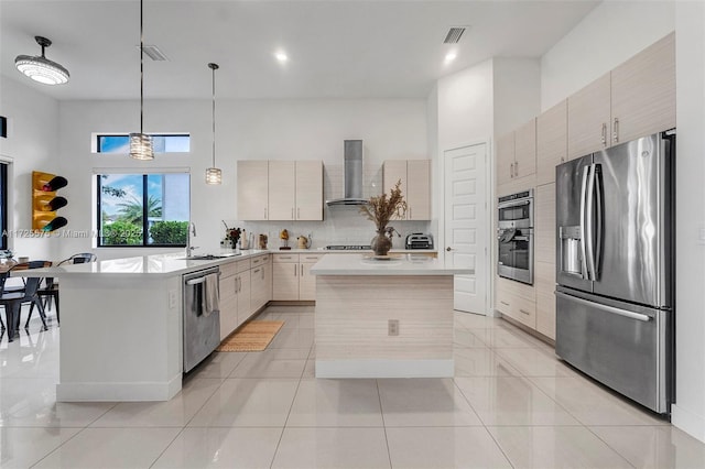 kitchen featuring tasteful backsplash, visible vents, appliances with stainless steel finishes, light countertops, and wall chimney range hood