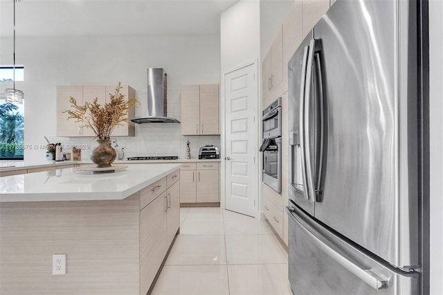 kitchen featuring wall chimney exhaust hood, stainless steel refrigerator with ice dispenser, backsplash, and modern cabinets