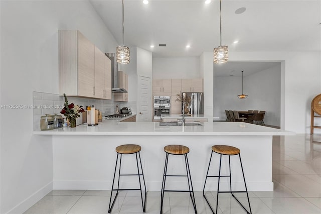 kitchen featuring light countertops, appliances with stainless steel finishes, and a kitchen breakfast bar