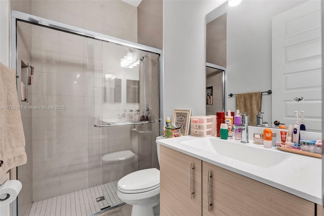 bathroom with a shower stall, vanity, and toilet