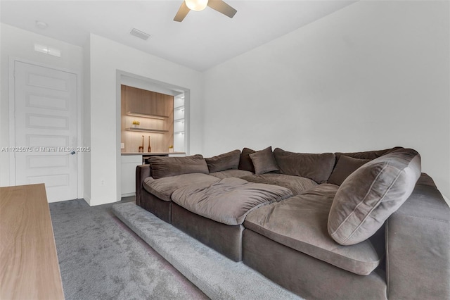 carpeted living area featuring visible vents and a ceiling fan